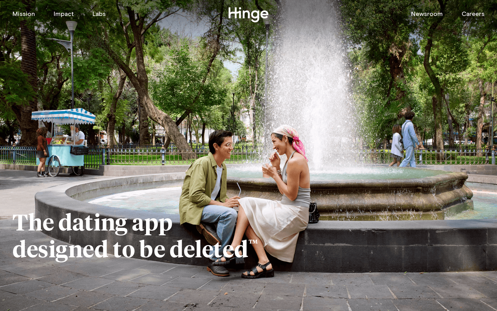 Hinge homepage showing the tagline The dating app designed to be deleted over a photo of two people talking by a fountain